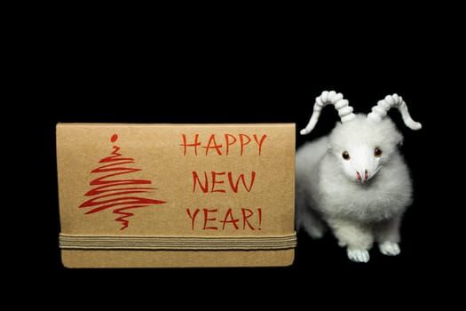 New Year greeting card or postcard with white goat or sheep toy the chinese symbol of 2015 year on black background