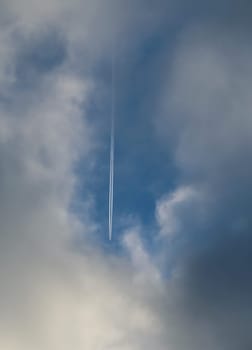 The plane flies low in the sky, leaving a white trail