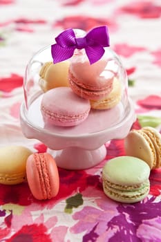 Colorful macarons on pink floor on blued tablecloth