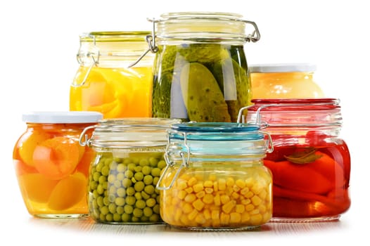 Jars with pickled vegetables and fruity compotes isolated on white background. Preserved food