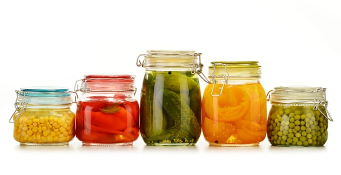 Jars with pickled vegetables and fruity compotes isolated on white background. Preserved food