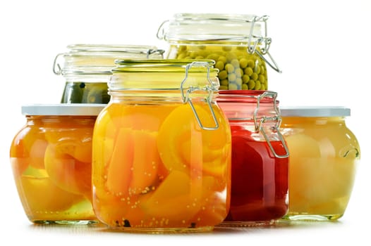 Jars with pickled vegetables and fruity compotes isolated on white background. Preserved food