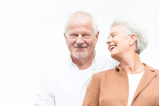 Active and happy senior couple in front of a bright sky