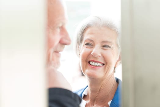 Two seniors stand at a public telephone booth and make phone calls