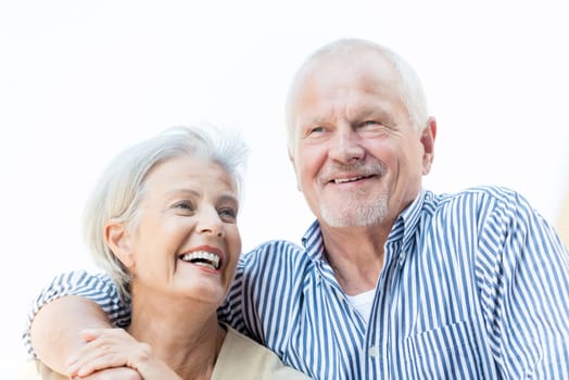 Active and happy senior couple in front of a white sky