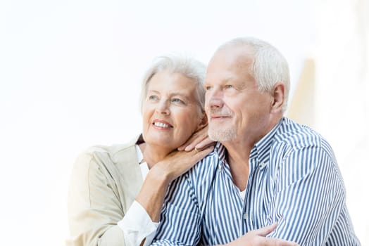 Active and happy senior couple in front of a white sky
