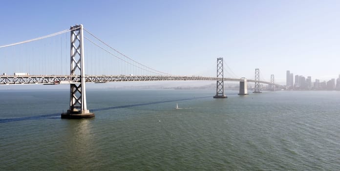 Vehicles and boats move along above and below the Bay Brdige in San Francisco