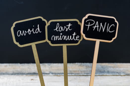Business message AVOID LAST MINUTE PANIC written with chalk on wooden mini blackboard labels, defocused chalkboard and wood table in background