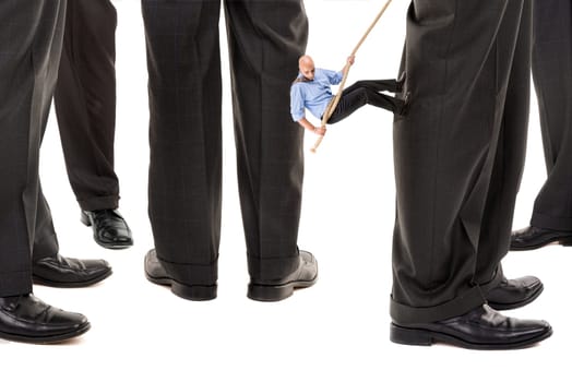 Small businessman climbing big business player's leg