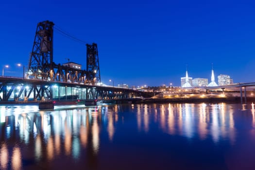 Water passes under the Steel Bridge in Portland with the convention center in the background