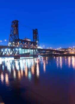Water passes under the Steel Bridge in Portland at night
