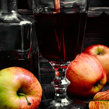 Warming autumn cocktail sangria with apple in glass wine glass.Dark key