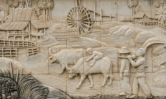 Stone carving of traditional Thai rural culture life in the past, Thailand