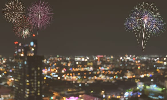 Firework on blurred twilight sky background with colorful city lights bokeh. Vintage filter effect image