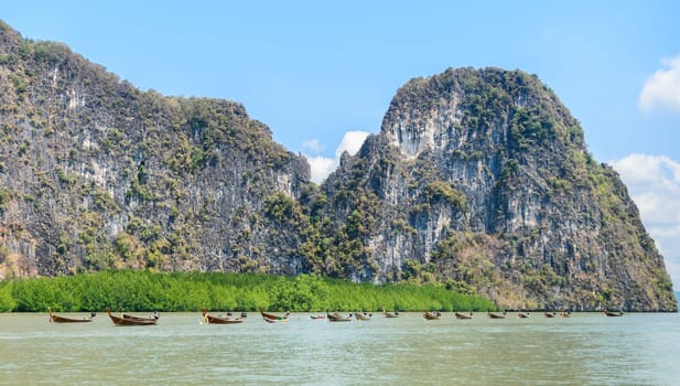 Landscapes of limestone island with mangrove forest and long-tail wooden boats in Phang Nga Bay National Park, Thailand
