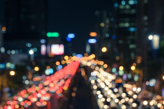 Blurred bokeh image of traffic jam in business area downtown. Defocused image of city night light