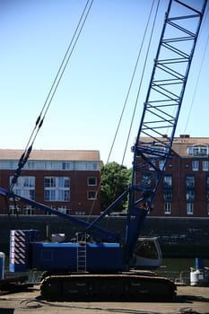 A crane for working on the river stands on a floating platform.