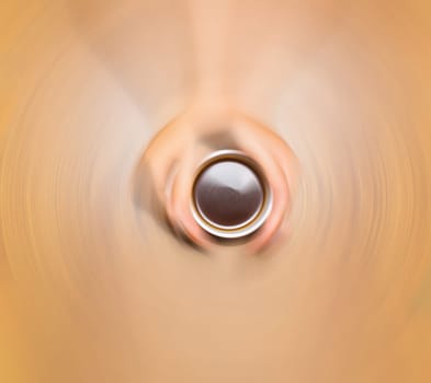 Female hands holding cup of coffee on wooden background, blurred in postproduction