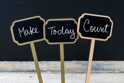 Motivational message Make Today Count written with chalk on wooden mini blackboard labels, defocused chalkboard and wood table in background