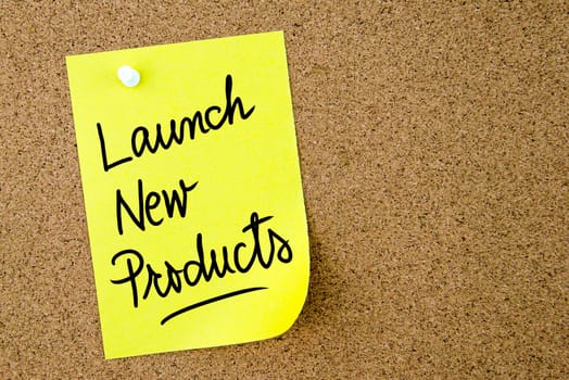 Launch New Products text written on yellow paper note pinned on cork board with white thumbtack. Business concept image with copy space available