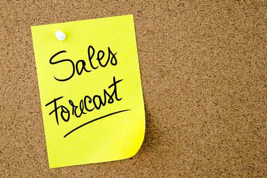 Sales Forecast text written on yellow paper note pinned on cork board with white thumbtack. Business concept image with copy space available