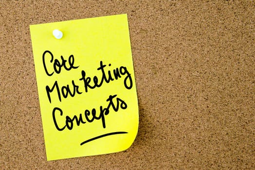Core Marketing Concepts text written on yellow paper note pinned on cork board with white thumbtack. Business concept image with copy space available