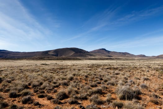 Full view of the mountains with green grass field in Graaff-Reinet.