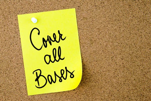 Cover All Bases text written on yellow paper note pinned on cork board with white thumbtack. Business concept image with copy space available