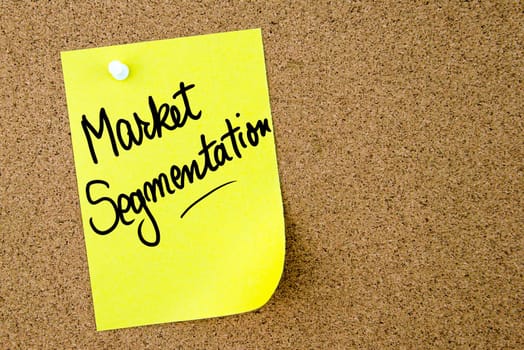 Market Segmentation text written on yellow paper note pinned on cork board with white thumbtack. Business concept image with copy space available