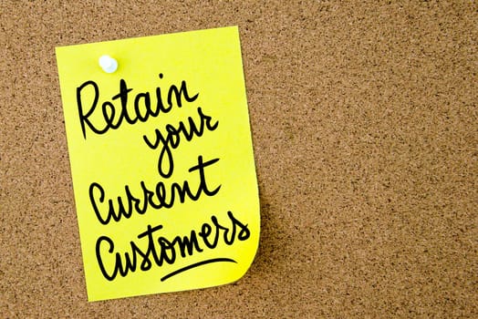 Retain Your Current Customers text written on yellow paper note pinned on cork board with white thumbtack. Business concept image with copy space available