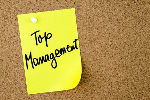 Top Management text written on yellow paper note pinned on cork board with white thumbtack. Business concept image with copy space available