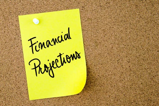 Financial Projections text written on yellow paper note pinned on cork board with white thumbtack. Business concept image with copy space available