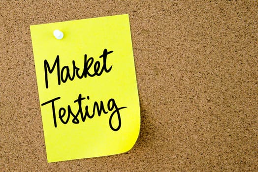 Market Testing text written on yellow paper note pinned on cork board with white thumbtack. Business concept image with copy space available