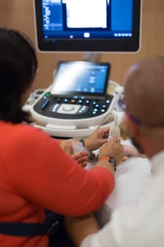 Female medical doctor students learning to do medical examination of patient with ultra sound scanner machine on ultrasound techniques workshop.