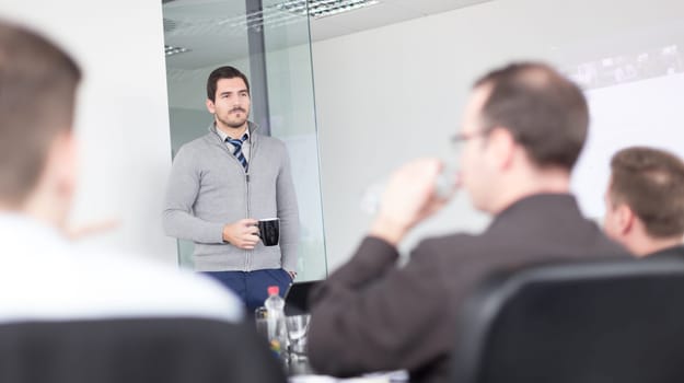 Relaxed cheerful team leader and business owner leading informal in-house business meeting. Business and entrepreneurship concept.
