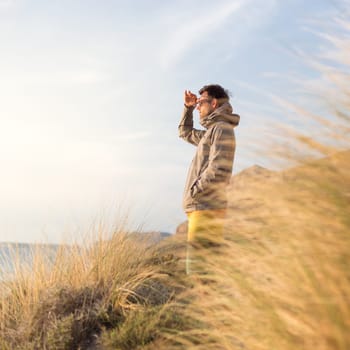 Sporty active man looking in distance, enjoying beauty of nature, freedom and life at beautiful landscape. Active lifestyle outdoors.