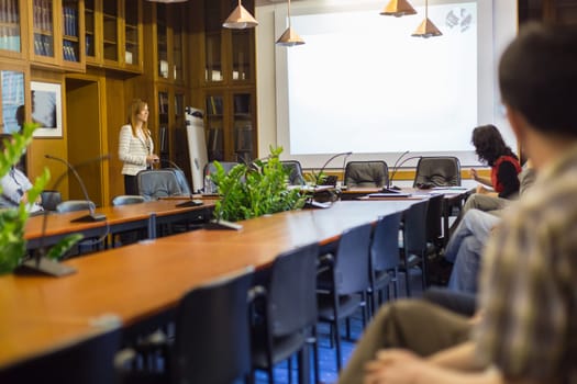 Doctoral thesis defense on faculty. Relaxed confident smart female student presenting hes study work in front of whiteboard to commission, defending hes thesis. Could also be job interview.