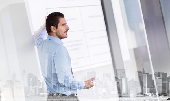 Business man making a presentation in front of whiteboard. Business executive delivering a presentation to his colleagues during meeting or in-house business training.