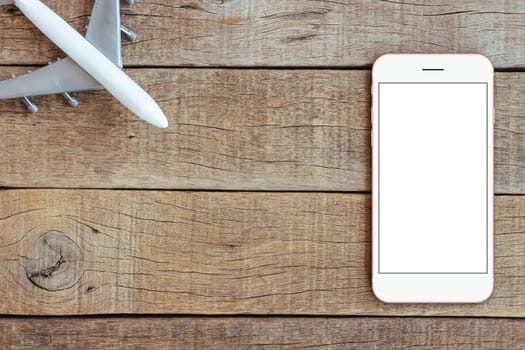 phone and airplane toy on wood table transport business concept top view, mock up phone blank screen