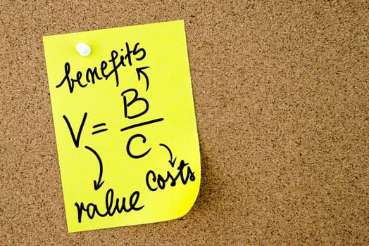 Value is Benefits per Costs text written on yellow paper note pinned on cork board with white thumbtack. Business concept image with copy space available