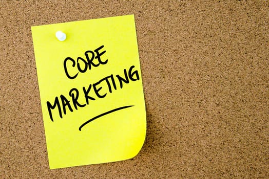 Core Marketing text written on yellow paper note pinned on cork board with white thumbtack. Business concept image with copy space available