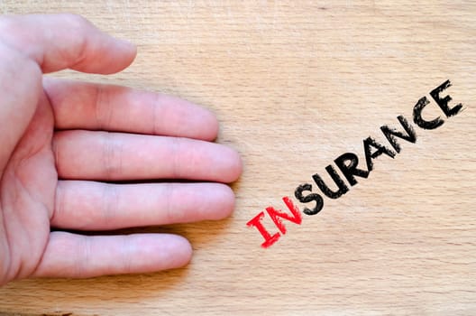 Human hand over wooden background and insurance text concept