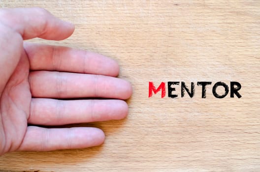 Human hand over wooden background and mentor text concept