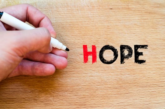 Human hand over wooden background and hope text concept