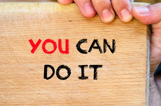 Human hand over wooden background and you can do it text concept