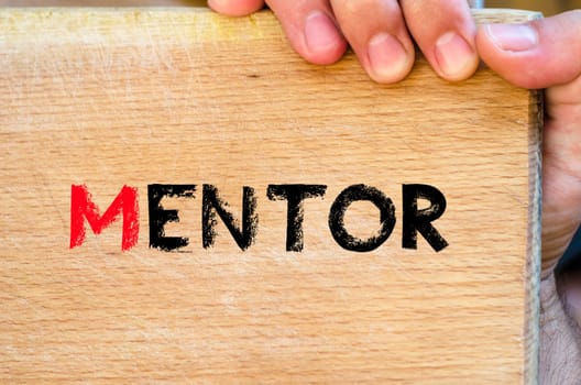 Human hand over wooden background and mentor text concept