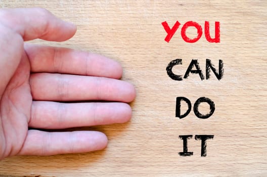 Human hand over wooden background and you can do it text concept