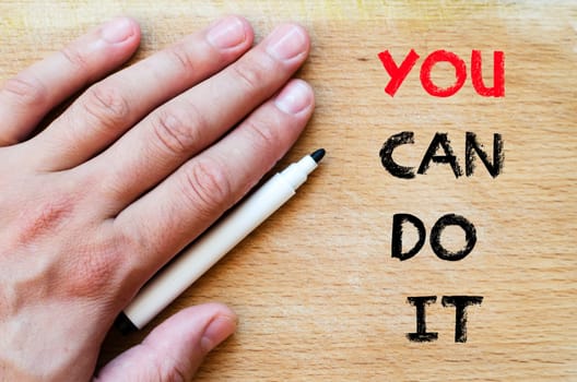Human hand over wooden background and you can do it text concept