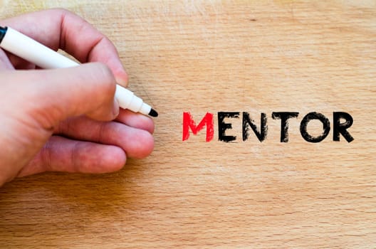 Human hand over wooden background and mentor text concept