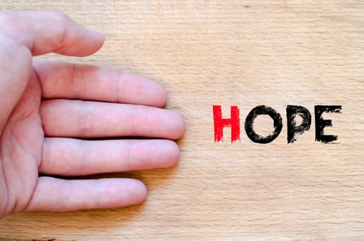 Human hand over wooden background and hope text concept